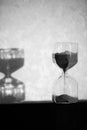 Hourglass with shadow on wall. Time passing concept for business deadline, urgency and running out of time. Sandglass Royalty Free Stock Photo