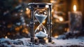 An hourglass sitting on top of a snow covered ground. Generative AI image. New Year card with yearclock.