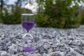 Hourglass on stones in a public park amid bushes Royalty Free Stock Photo