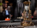 The hourglass is on the table. Photograph of a retro hourglass. Time.