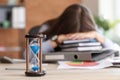 Hourglass on table of stressed businesswoman missing deadlines