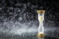 hourglass under the water drops on black background. Time limited. Deadline. Marketing strategy.