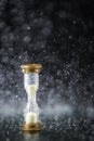 Hourglass under the water drops isolated on black background. Time limited. Deadline. Marketing strategy.