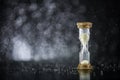 Hourglass under the water drops isolated on black background. Time limited. Deadline. Marketing strategy. Royalty Free Stock Photo