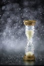 Hourglass under the water drops isolated on black background. Time limited. Deadline. Marketing strategy.