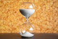 Hourglass with white sand dripping.