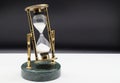 Hourglass on white table isolated on black background. Time passing concept Royalty Free Stock Photo