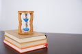 Hourglasses and book on a wooden table