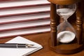 Hourglasses and book on a wooden table