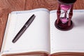 Hourglasses and book on a wooden table