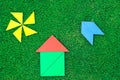 House, aircraft and sun made of tangram figures on natural grass Royalty Free Stock Photo