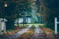 House in autumn forest with driveway at dusk. Royalty Free Stock Photo