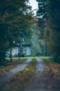 House in autumn forest with driveway at dusk. Royalty Free Stock Photo