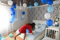 HOUSE AFTER BIRTH. decorated room for a young mother. surprise at home. Mother holds her baby in her arms in a white bedroom. Love