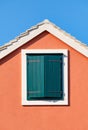 The house on blue sky background. Roof and window with shutters. Architectural composition.