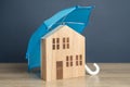 House with blue umbrella. Property insurance. Financial security.