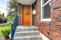 House with brick trim. Entrance porch with orange door Royalty Free Stock Photo