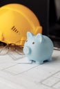 House building costs concept. Safety helmet and piggy bank close-up. Vertical image Royalty Free Stock Photo