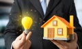 A house and a burning light bulb. Smart home. Electricity and autonomy. Energy efficient living Royalty Free Stock Photo