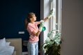 Caucasian woman housewife wearing casual clothes and rubber gloves cleaning window glass in bedroom Royalty Free Stock Photo