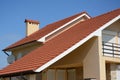 House with clay tile roof, rain gutter, chimney, gable and valley type of roof construction. Building attic house construction wit Royalty Free Stock Photo