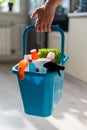 House cleaning concept. Faceless woman holds cleaning products in a blue basket. Closeup of the hands of a female Royalty Free Stock Photo