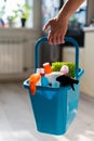 House cleaning concept. Faceless woman holds cleaning products in a blue basket. Closeup of the hands of a female Royalty Free Stock Photo