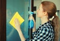 House cleaning concept - housewife or cleaner, happy smiling woman holding dry microfiber rag and detergent spray bottle washing Royalty Free Stock Photo