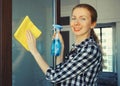 House cleaning concept - housewife or cleaner, happy smiling woman holding dry microfiber rag and detergent spray bottle washing Royalty Free Stock Photo