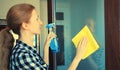 House cleaning concept - housewife or cleaner, happy smiling woman holding dry microfiber rag and detergent spray bottle washing Royalty Free Stock Photo