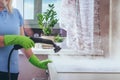 House cleaning. Girl brushes steam cleaners kitchen white electronic parable steam in green gloves. cleaning of a surface