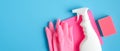 House cleaning service concept. Cleaning supplies on blue background. Top view pink sponge, rubber gloves, napkin and cleaning Royalty Free Stock Photo