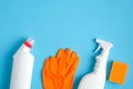 House cleaning supplies on blue background. Cleaning service and housekeeping concept. Flat lay spray bottle, cleaning detergent, Royalty Free Stock Photo