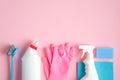 House cleaning tools and cleaning products on pink background. Top view blue sponge, gloves, brush and cleaner bottles. Cleaning Royalty Free Stock Photo