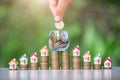 House on the coin ladder.In a glass jar have coins.The hand of a business person is going to place a coin.The concept of real Royalty Free Stock Photo