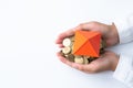 House and coins in the hands of investors.Orange roof house.Save money for buying a new home and borrowing money to plan the real Royalty Free Stock Photo