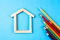 House and colored pencils on a blue background Royalty Free Stock Photo