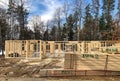 House construction site with wall studs and stacks of wood trusses