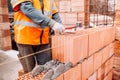 house construction site, worker building the brick wall with trowel, cement and mortar Royalty Free Stock Photo