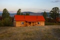 House in the countryside with the mountains in the background. Farm cabin in the rural country surrounded by forest and hills with Royalty Free Stock Photo