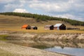 House in the countryside with the mountains in the background on a river bank. Farm cabin in the rural country surrounded by Royalty Free Stock Photo