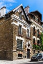 House covered by ivy with geraniums fill boxes. Montmartre, Paris