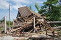 A house damaged by hurricane with fallen tree in front and on the house