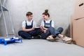 House decoration DIY renovation concept Happy couple sitting on floor in empty room of new home planning design. Husband Royalty Free Stock Photo