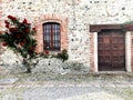 House decored with red roses a window and wooden door facade Royalty Free Stock Photo