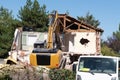 House demolition demolishing building with a large backhoe Royalty Free Stock Photo