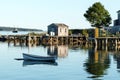 House, dock, row boat and lobster traps reflecting in the water Royalty Free Stock Photo