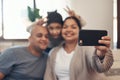 A house doesnt make a home, a family does. a happy young family taking selfies with a smartphone on the sofa at home. Royalty Free Stock Photo