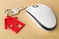 House door key with red house key chain pendant and computer mou Royalty Free Stock Photo