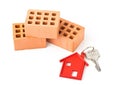 House door key with red house key chain pendant and bricks Royalty Free Stock Photo
